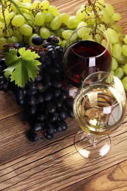 Kırmızı şarap ve beyaz şarap üzüm ve rustik zemin üzerine gözlük ile