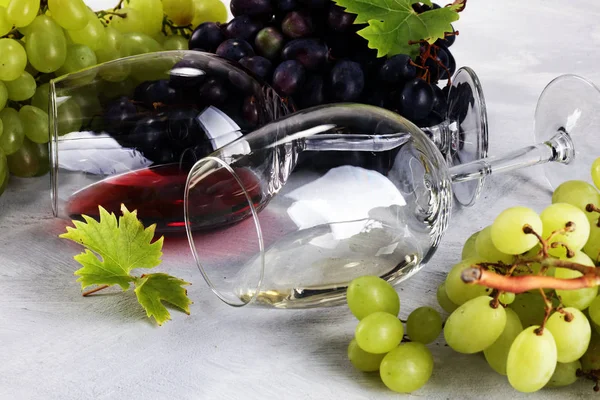 Kırmızı şarap ve beyaz şarap üzüm ve rustik zemin üzerine gözlük ile