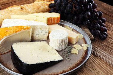 Rustik plaka üzerinde farklı peynir peynir tabağı.