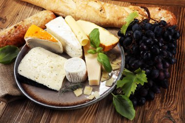 Rustik plaka üzerinde farklı peynir peynir tabağı.