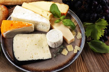 Rustik plaka üzerinde farklı peynir peynir tabağı.