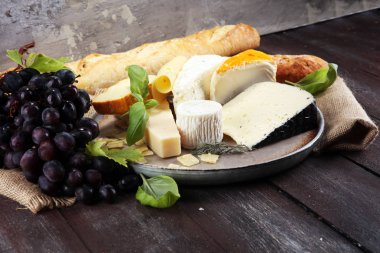 Rustik plaka üzerinde farklı peynir peynir tabağı.