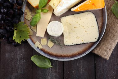 Rustik plaka üzerinde farklı peynir peynir tabağı.