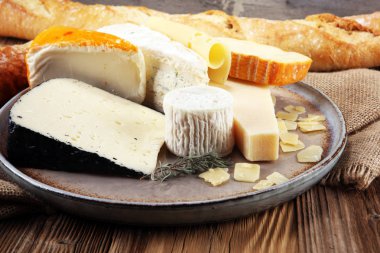 Rustik plaka üzerinde farklı peynir peynir tabağı.