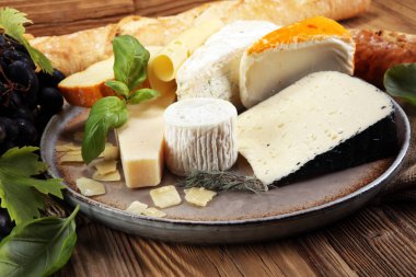 Rustik plaka üzerinde farklı peynir peynir tabağı.