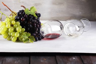 Kırmızı şarap ve beyaz şarap üzüm ve rustik zemin üzerine gözlük ile