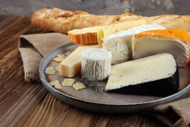 Rustik plaka üzerinde farklı peynir peynir tabağı.