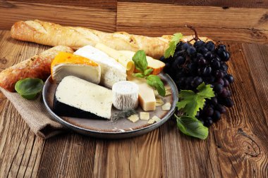 Rustik plaka üzerinde farklı peynir peynir tabağı.