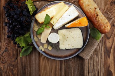 Rustik plaka üzerinde farklı peynir peynir tabağı.