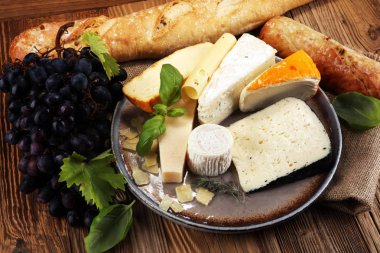 Rustik plaka üzerinde farklı peynir peynir tabağı.