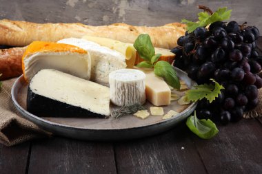 Rustik plaka üzerinde farklı peynir peynir tabağı.