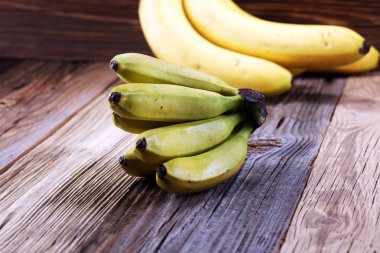 Bir banch mini muz ve bir tablo üzerinde büyük muz.