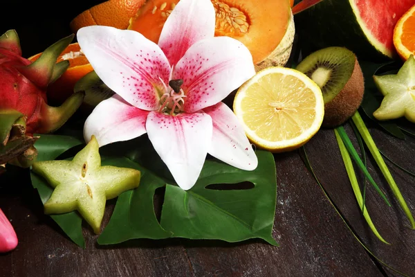 Tropical fruit. Assortment of tropical fruits with leaves of palm trees and exotic plants