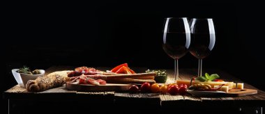 İtalyan antipasti şarap aperatifler küme. Peynir çeşitli, Akdeniz zeytin, crudo, Prosciutto di Parma, salam ve ahşap grunge arka plan üzerinde bardaklarda şarap