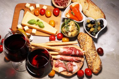 İtalyan antipasti şarap aperatifler küme. Peynir çeşitli, Akdeniz zeytin, crudo, Prosciutto di Parma, salam ve taş grunge arka plan üzerinde bardaklarda şarap
