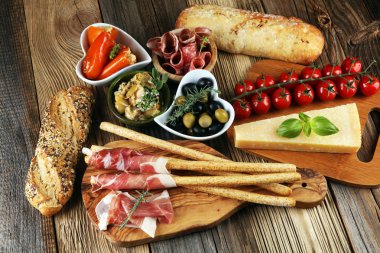 İtalyan antipasti şarap aperatifler küme. Peynir çeşitli, Akdeniz zeytin, crudo, Prosciutto di Parma, salam ve ahşap grunge arka plan üzerinde bardaklarda şarap