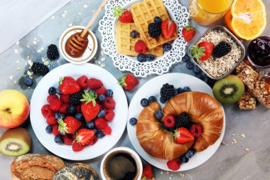 Waffle, kruvasan, kahve ve meyve suyu ile masada Kahvaltı