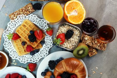 Waffle, kruvasan, kahve ve meyve suyu ile masada Kahvaltı