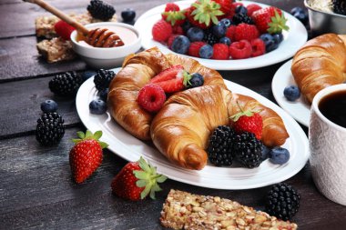 Lezzetli kahvaltı taze kruvasanlar ve eski mermer zemin üzerine olgun çilek ile