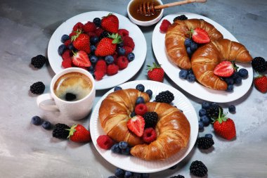 Lezzetli kahvaltı taze kruvasanlar ve eski mermer zemin üzerine olgun çilek ile
