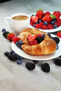 Lezzetli kahvaltı taze kruvasanlar ve eski mermer zemin üzerine olgun çilek ile
