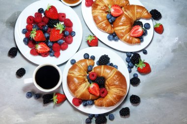 Lezzetli kahvaltı taze kruvasanlar ve eski mermer zemin üzerine olgun çilek ile