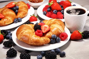 Lezzetli kahvaltı taze kruvasanlar ve eski mermer zemin üzerine olgun çilek ile