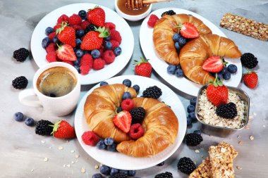 Lezzetli kahvaltı taze kruvasanlar ve eski mermer zemin üzerine olgun çilek ile