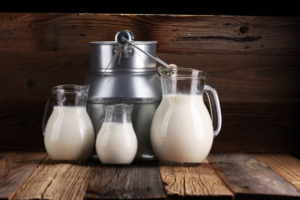 Ein Krug Milch Und Ein Glas Milch Auf Einem Holztisch — Stockfoto