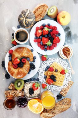 Waffle, kruvasan, kahve ve meyve suyu ile masada Kahvaltı