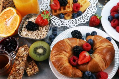 Waffle, kruvasan, kahve ve meyve suyu ile masada Kahvaltı