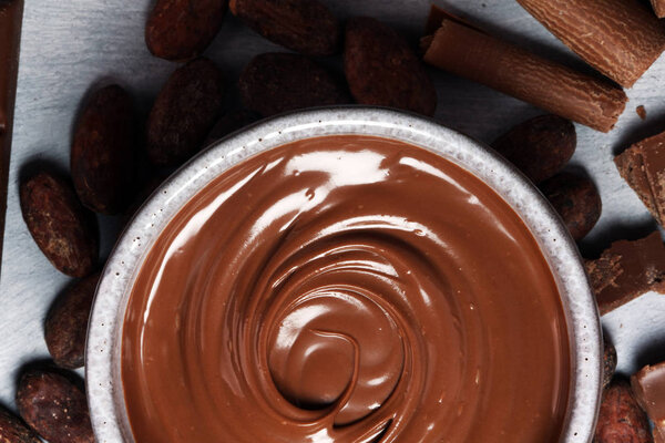 Таяние шоколада или расплавленного шоколада с шоколадной завихрением. Много стека и фишек с порошком
