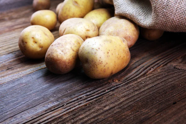 potato food . Fresh raw organic potatoes on old vintage background