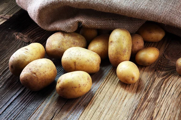 potato food . Fresh raw organic potatoes on old vintage background