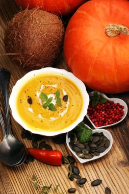 Ahşap arka plan üzerinde krem ve kabak çekirdeği ile kavrulmuş kabak ve havuç çorbası