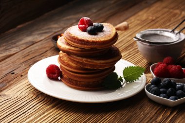 Çilek ve akçaağaç şurubu rustik masada krep.