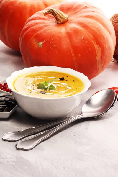 Taş zemin üzerine krem ve kabak çekirdeği ile kavrulmuş kabak ve havuç çorbası