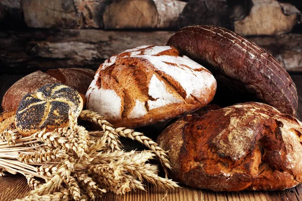 Different kinds of bread and bread rolls on board from above. Kitchen or bakery poster design.