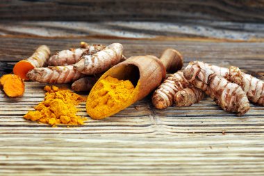 Taşra arka planında zerdeçal tozu ve taze zerdeçal..