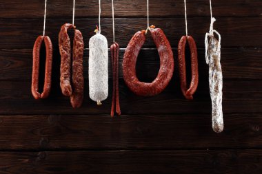 Sosisler markette askıda asılı duruyor. Taşra tarzı. Geleneksel yemek. Tütsülenmiş sosis eti sallanıyor.