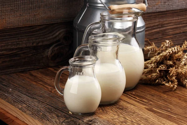 Ein Krug Milch Und Ein Glas Milch Auf Einem Holztisch — Stockfoto