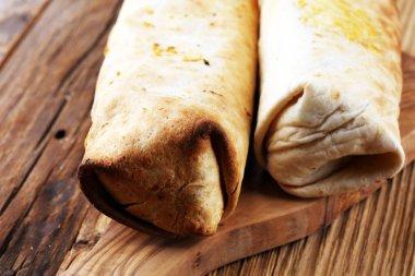 Burrito ile sığır eti ve sebze ahşap arka plan üzerinde tamamladı. Sığır börek, Meksika yemeği.