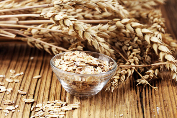 Oatmeal and oatmeal on the wooden background. Healthy eating concept.