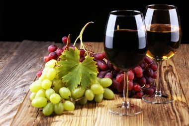 Beyaz şarap ve kırmızı şarap bir bardak ile sonbahar üzüm rustik arka plan üzerinde