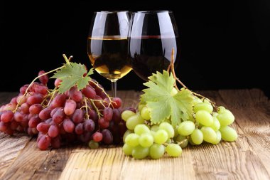 Beyaz şarap ve kırmızı şarap bir bardak ile sonbahar üzüm rustik arka plan üzerinde