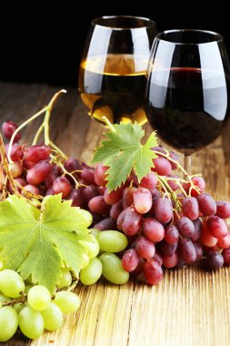 Beyaz şarap ve kırmızı şarap bir bardak ile sonbahar üzüm rustik arka plan üzerinde