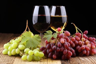 Beyaz şarap ve kırmızı şarap bir bardak ile sonbahar üzüm rustik arka plan üzerinde