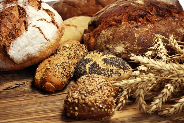 Different kinds of bread and bread rolls on board from above. Kitchen or bakery poster design.