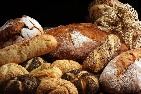 Different kinds of bread and bread rolls on board from above. Kitchen or bakery poster design.