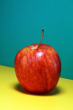 Olgun kırmızı elma renkli arka plan üzerinde. düz lay